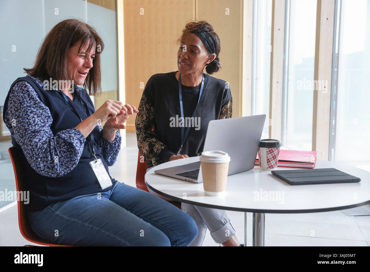 Coworkers using sign language in office Stock Photo