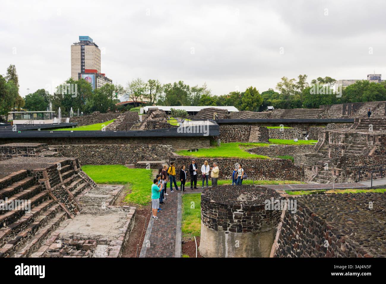 Tourists with guide in the Plaza of the Three Cultures. The Aztecc ...