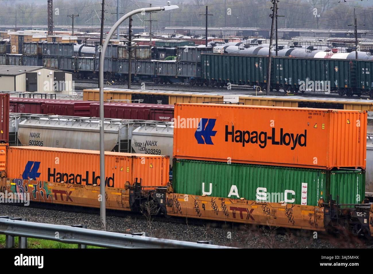 A Norfolk Southern freight pulls a consist of shipping containers pulls ...