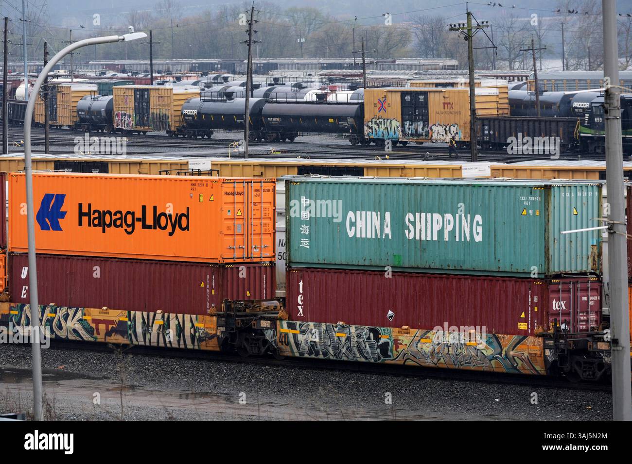 A Norfolk Southern freight pulls a consist of shipping containers pulls ...