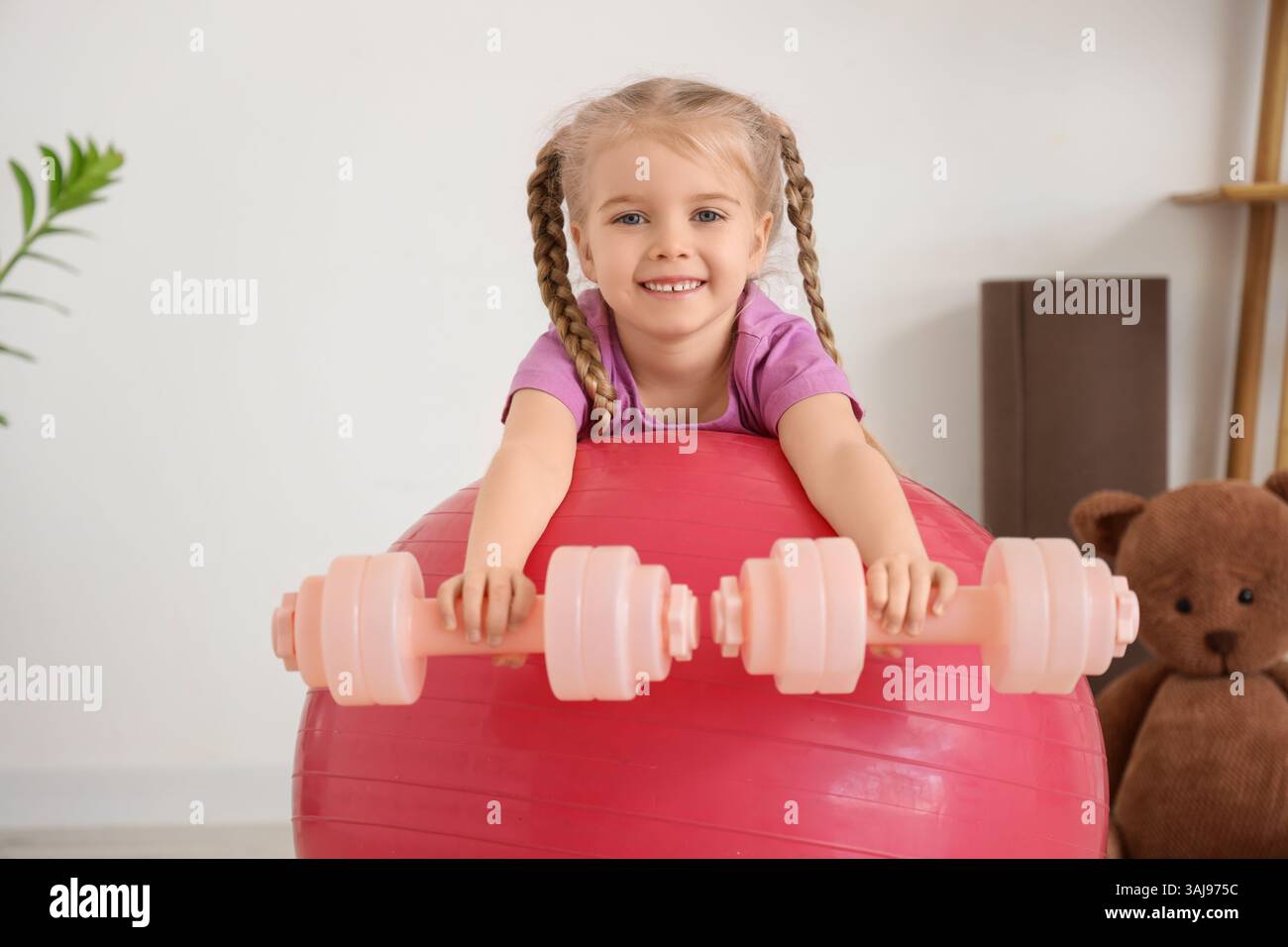 Sporty little girl with dumbbells and fitball at gym Stock Photo - Alamy