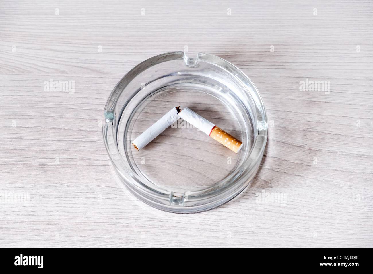 Broken Cigarette in Ashtray on the Table closeup Stock Photo