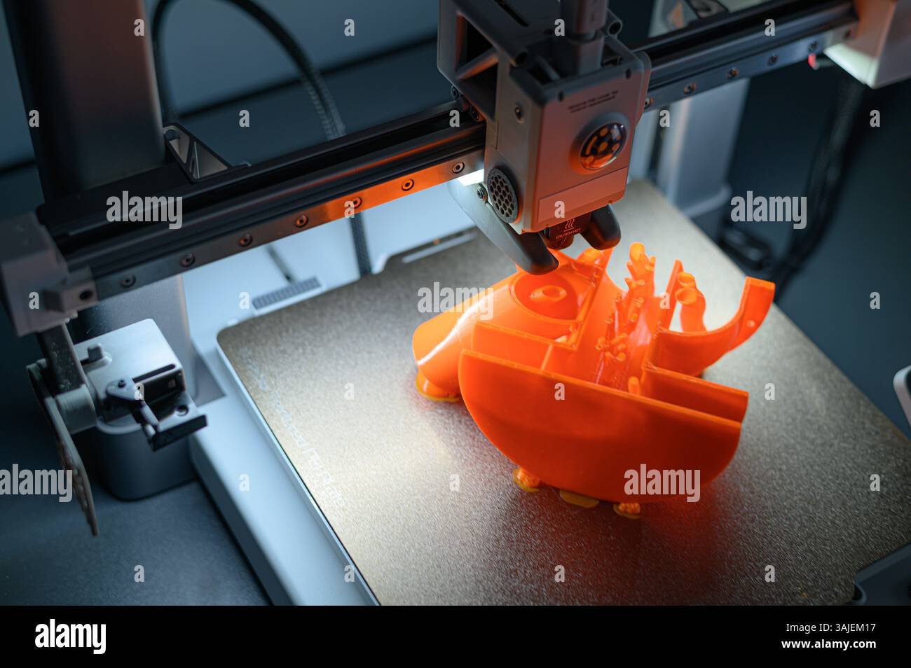 3D Printer Creating Vibrant Orange Prototype Model Stock Photo