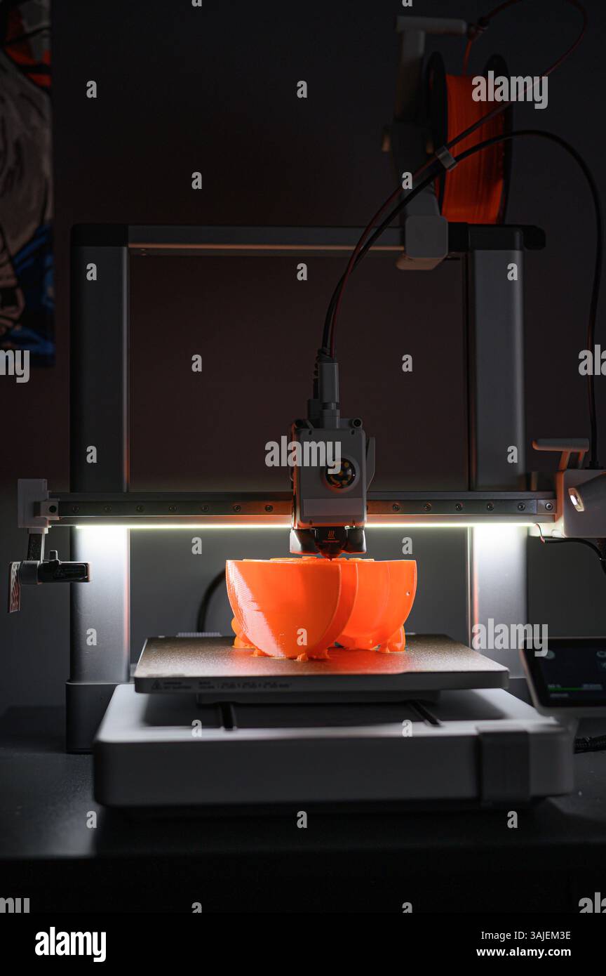 3D Printer Creating Vibrant Orange Prototype Model Stock Photo