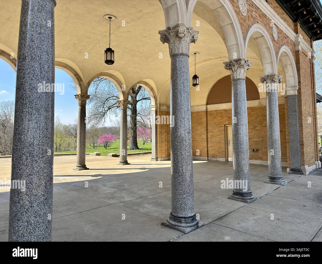Granite columns and arched portico overlook blooming spring parkland ...