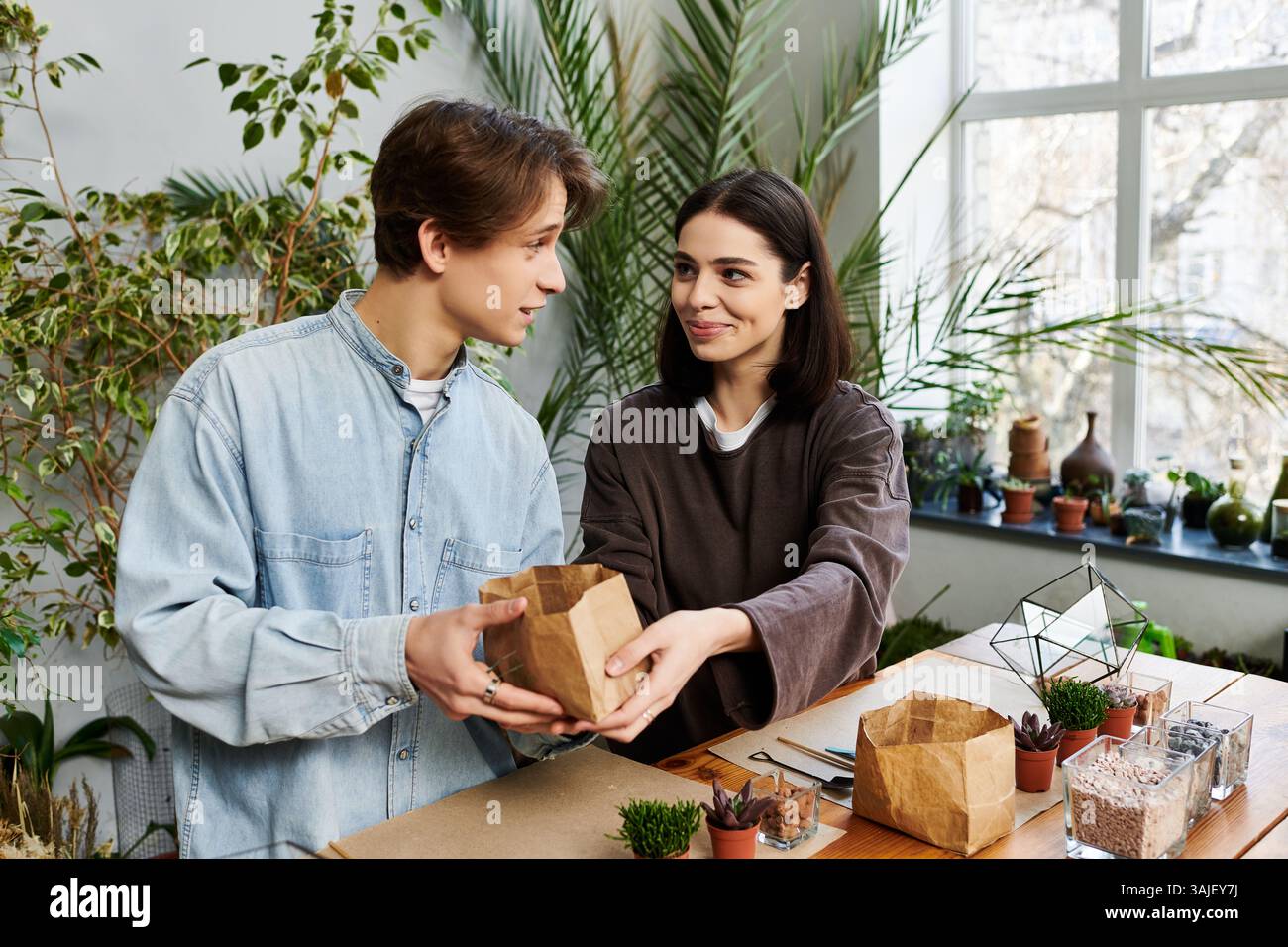 Creative couple collaborate, sharing ideas and materials in a lively studio. Stock Photo