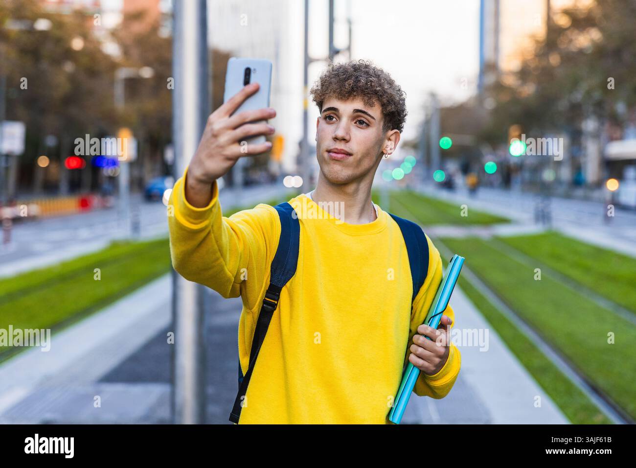 College student taking selfie with smartphone in city street Stock Photo