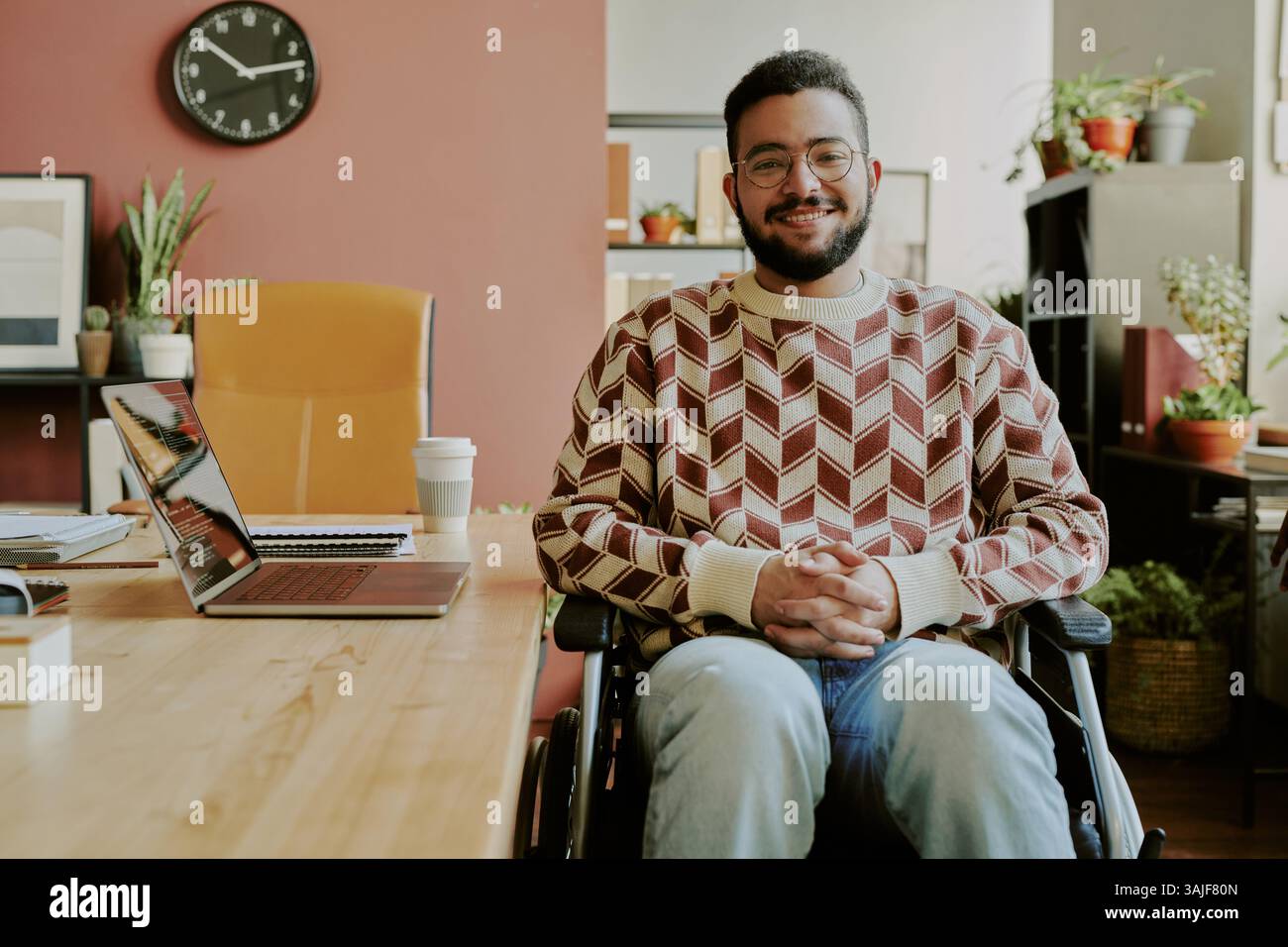 Medium portrait of handsome bearded senior developer with disability posing for photo in cozy spacious office Stock Photo