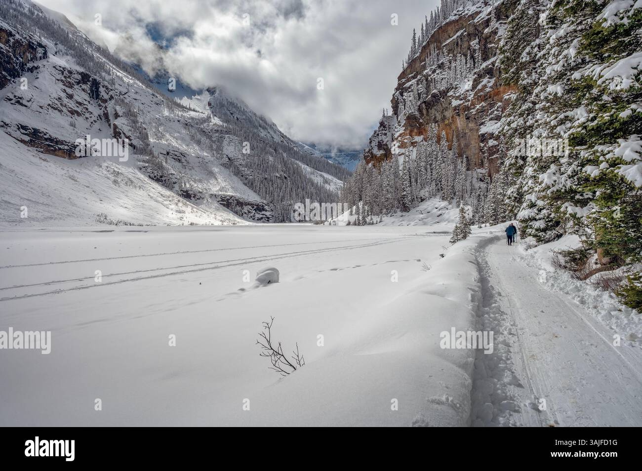 Hiking trail beside frozen Lake Louise in Banff National Park, Alberta ...