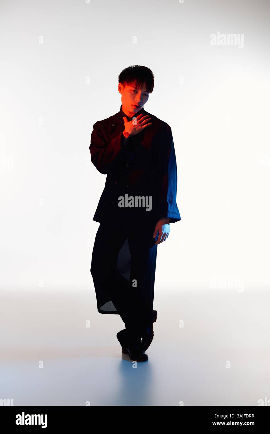 Stylish young man confidently poses against dramatic background ...