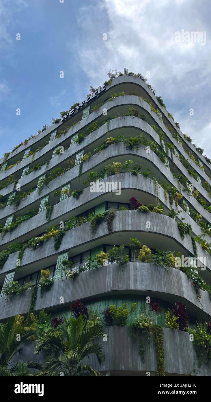 Modern eco-friendly building with vertical gardens and lush balconies, sustainable architecture in the city. - Smartphone Captured Stock Image