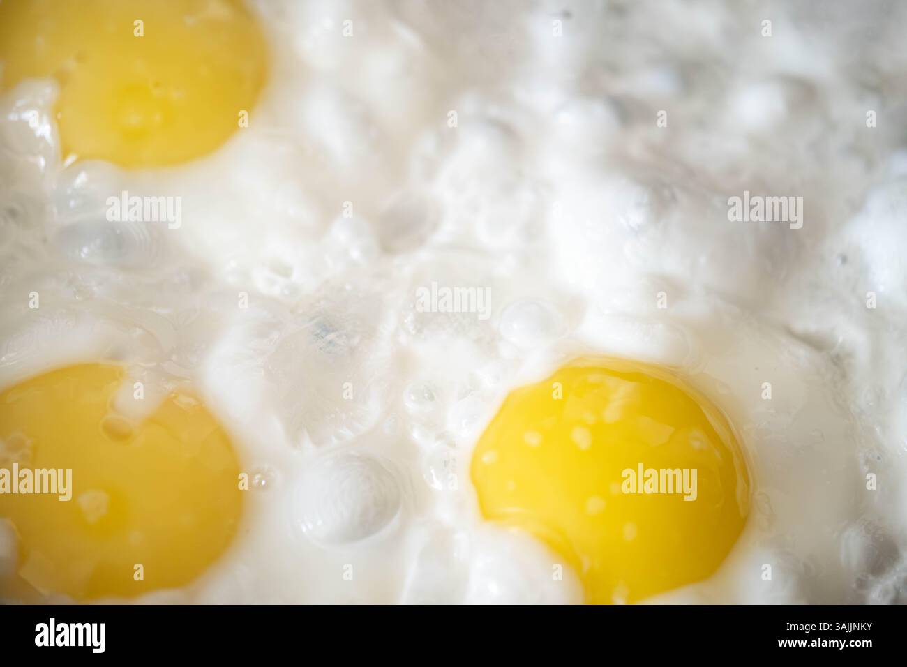 Background. Three fried eggs in closeup Stock Photo