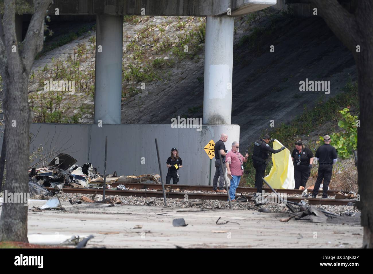 Emergency personnel covers a body as they respond to the area where a ...
