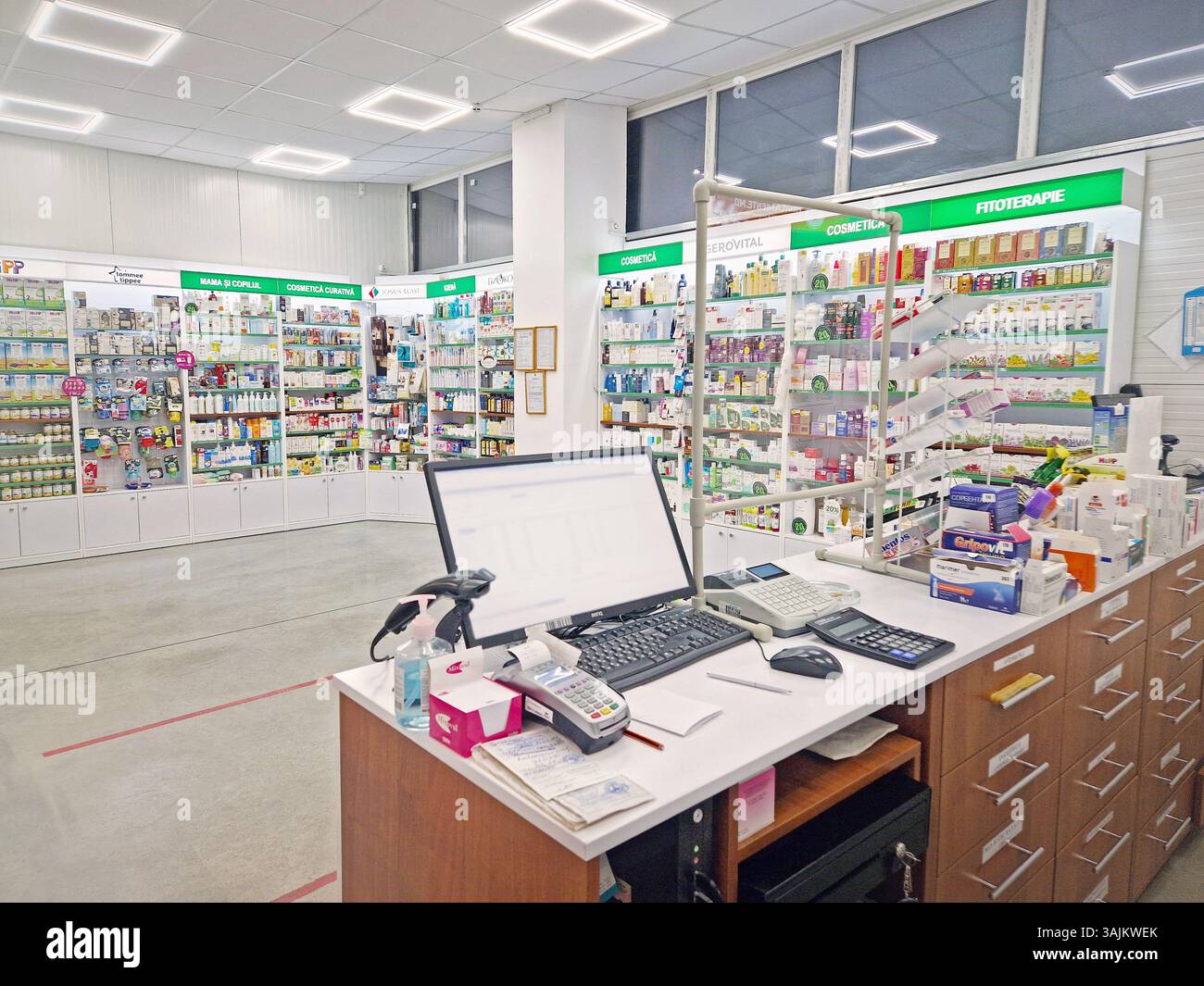UNGHENI, MOLDOVA - JANUARY 20, 2024 View inside a pharmacy with the seller counter, computer and cash register against stocked shelves with medicines. - Smartphone Captured Stock Image