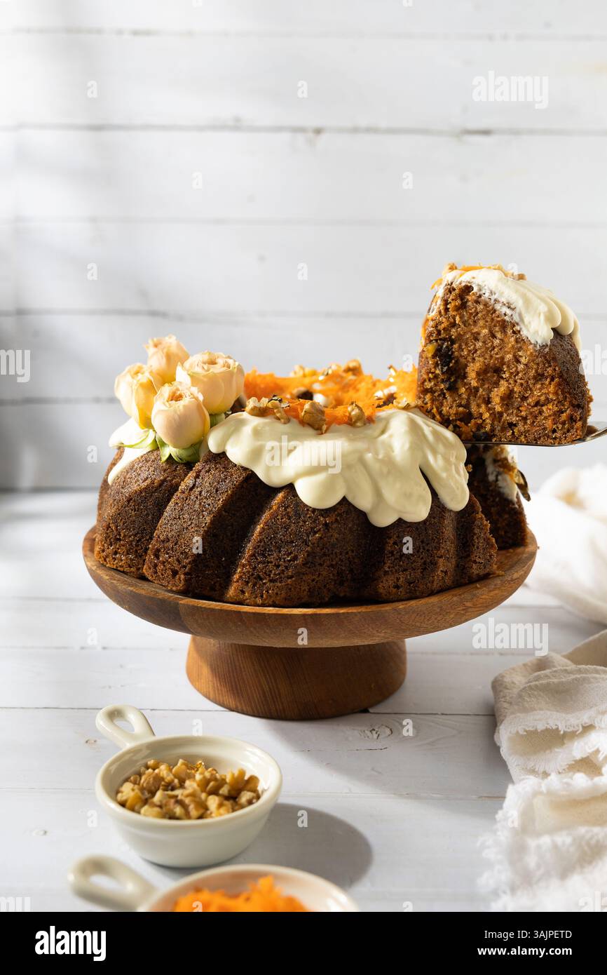 Carrot Cake with Cream Cheese Frosting and Fresh Flowers – White Wooden Background Stock Photo