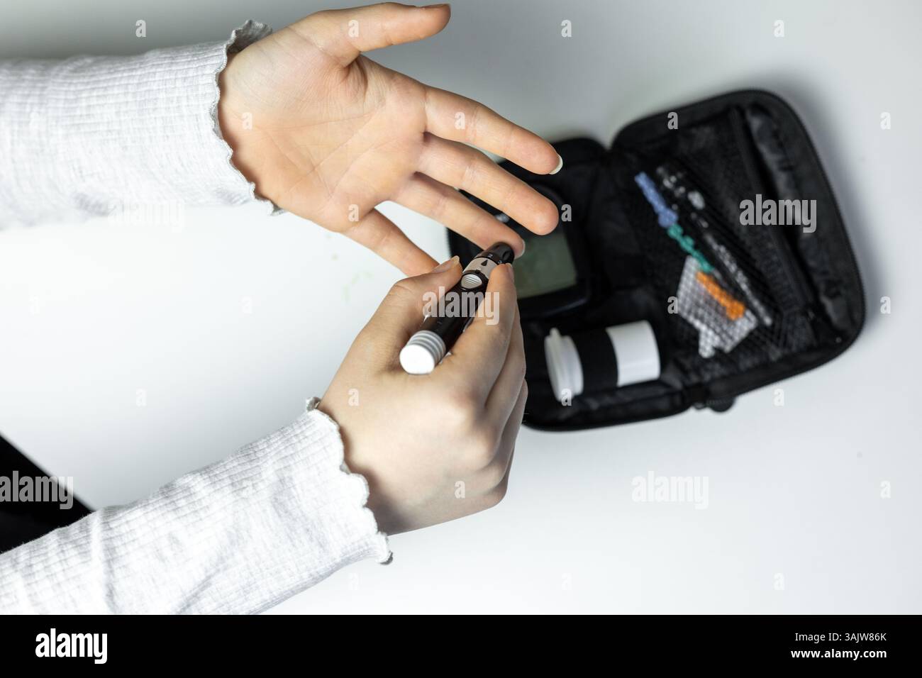 A person is about to give themselves an insulin injection, holding a pen device in their hand. A diabetes management kit is visible nearby, including Stock Photo