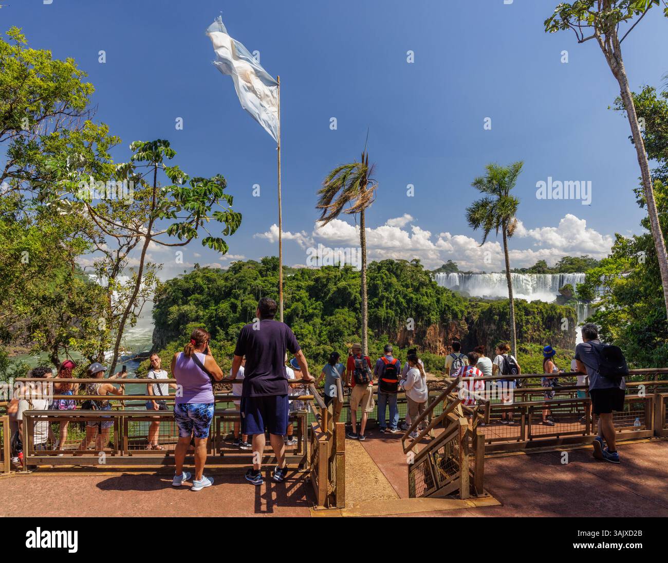 Puerto Iguazu, Misiones, Argentina - April 5th, 2025: Tourists watching Iguazu Falls from the lower circuit in Argentina. Stock Photo