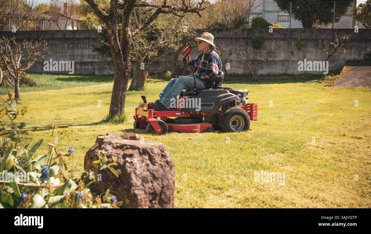 Man on riding lawn mower Stock Photo - Alamy