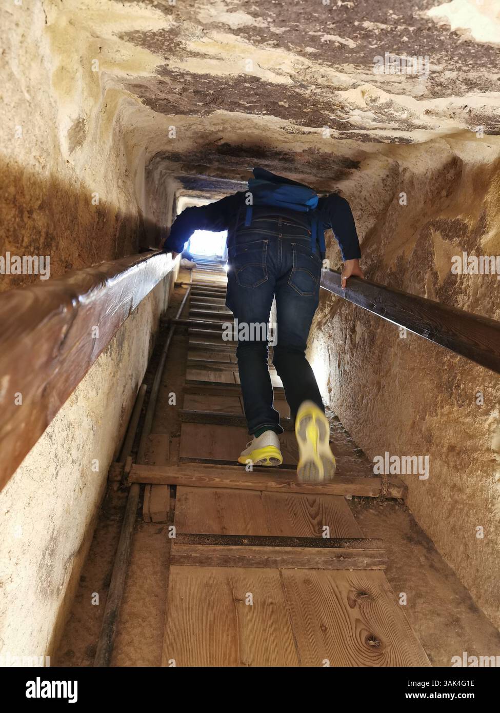 Climbing the steep ramp inside the Great Khufu Pyramid of Giza to access the kings burial chamber. This is not for the claustrophobic! - Smartphone Captured Stock Image