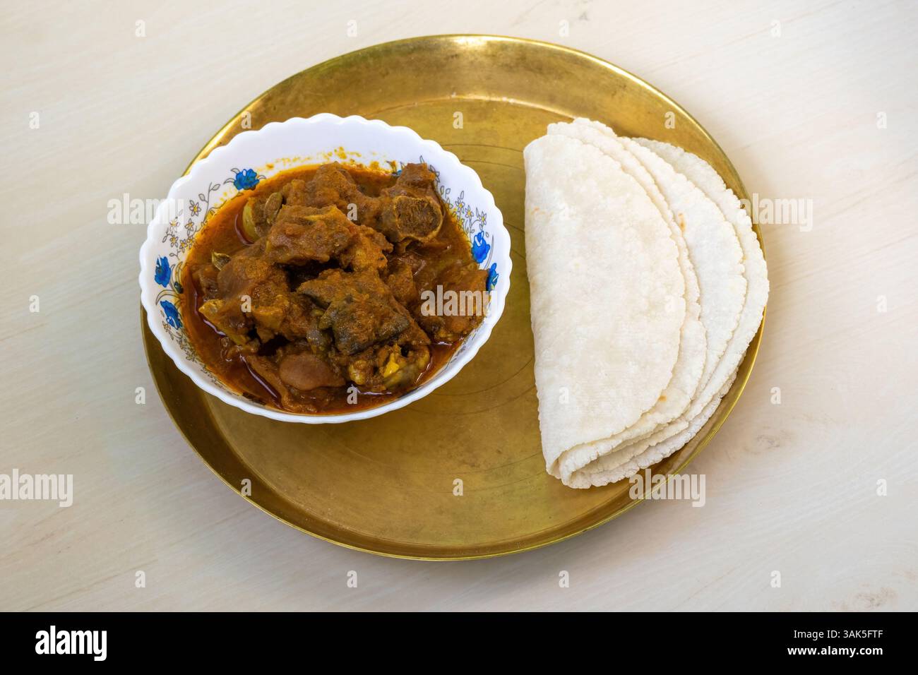 Mutton Ruti Tasty mutton curry and roti (flatbread) served on a brass plate on a ...
