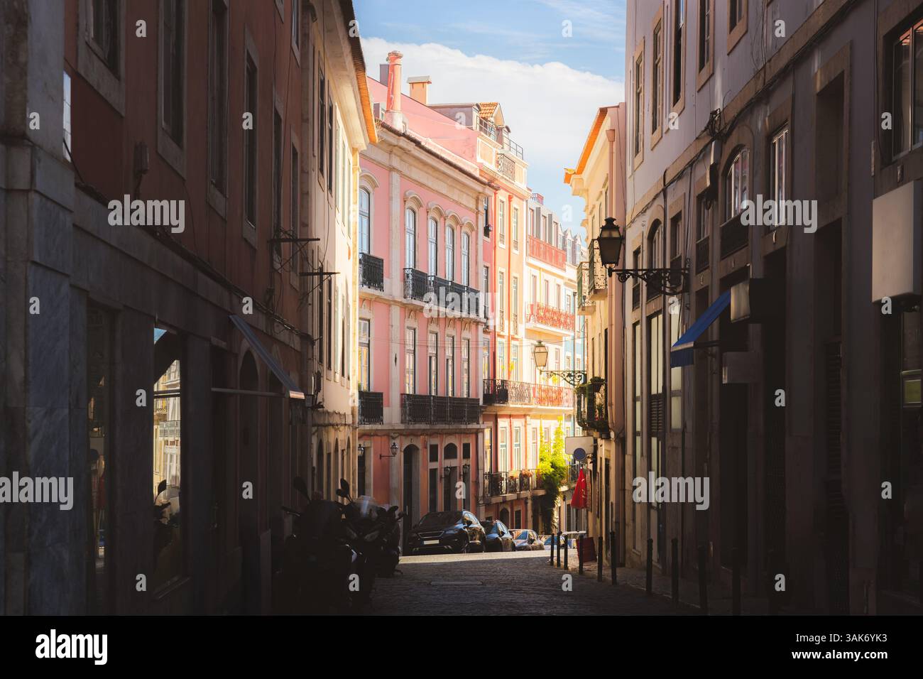 A narrow cobblestone street in Bairro Alto, Lisbon, is lined with ...