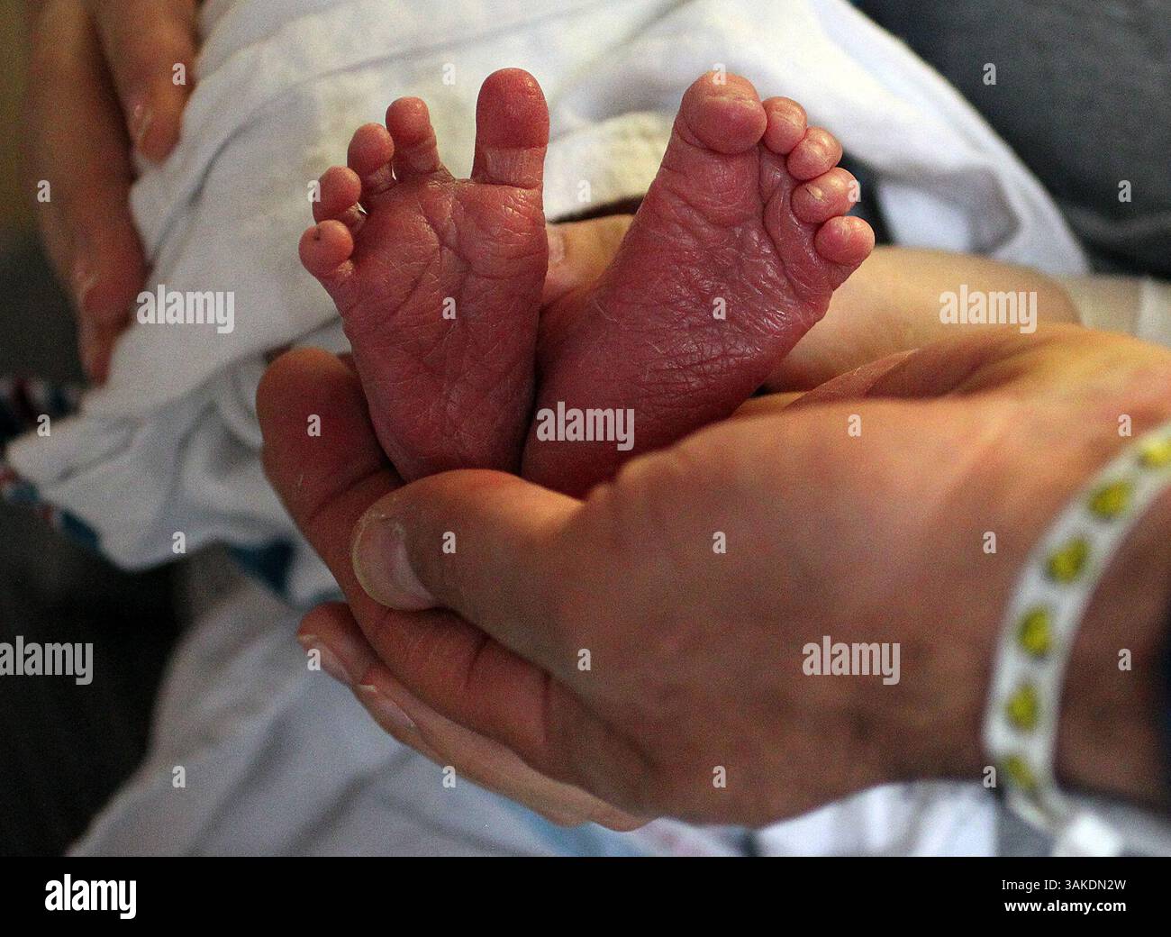 May 4, 2017 - Akron, OH, USA - Tony Maroon holds his newborn son's feet on May 4, 2017, at Summa Akron City Hospital in Akron, Ohio. Erin and Tony have donated a CuddleCot, a refrigerated bassinet that allows grieving parents of stillborn babies to be with their baby longer after the loss, to Akron Children's Hospital. The couple started a a foundation after they only had a few hours to be with their baby, who died in 2015, to provide these bassinets. (Credit Image: © Leah Klafczynski/TNS via ZUMA Wire) Stock Photo