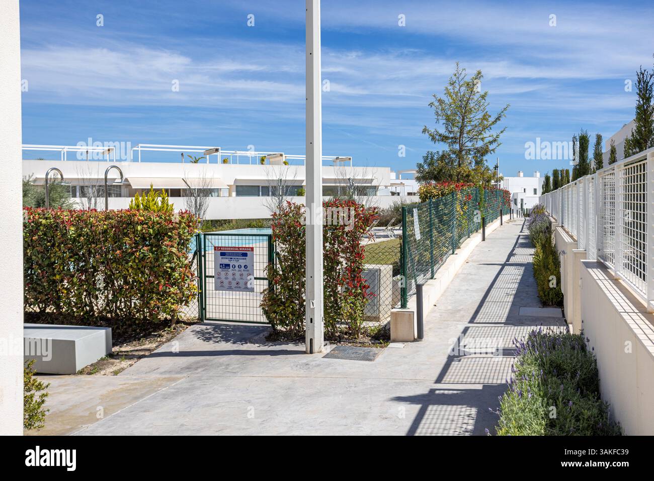 Picture of Gated access to a shared community pool surrounded by trimmed hedges ...
