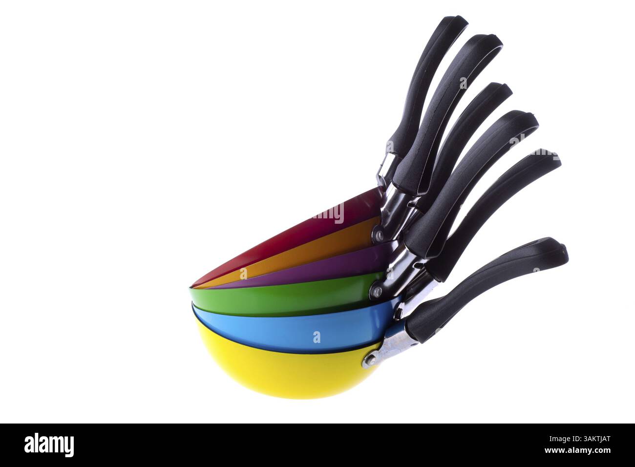 Many stacked colorful frying pans isolated over white Stock Photo