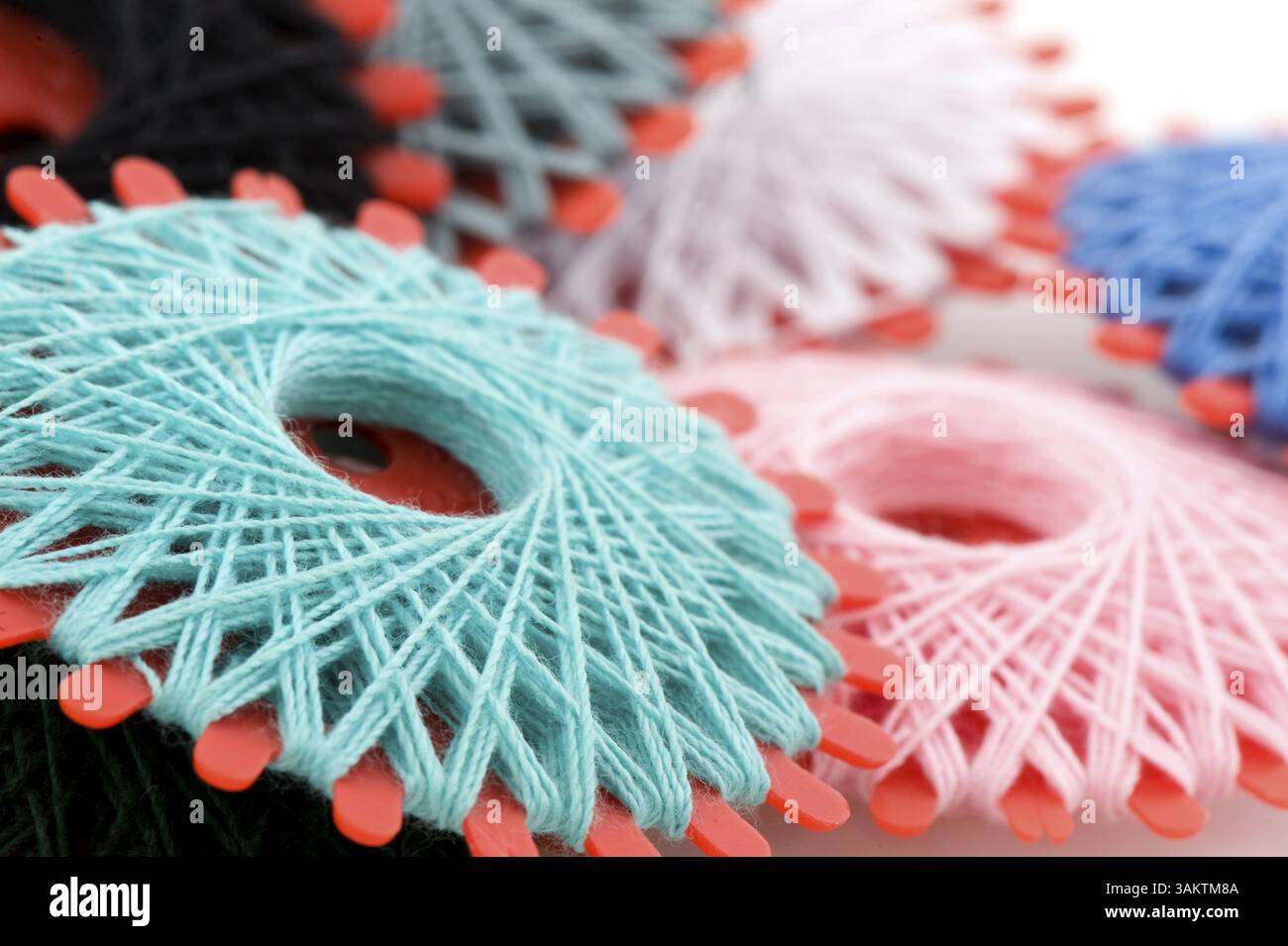 Many bobbins with different colored threads for sewing Stock Photo