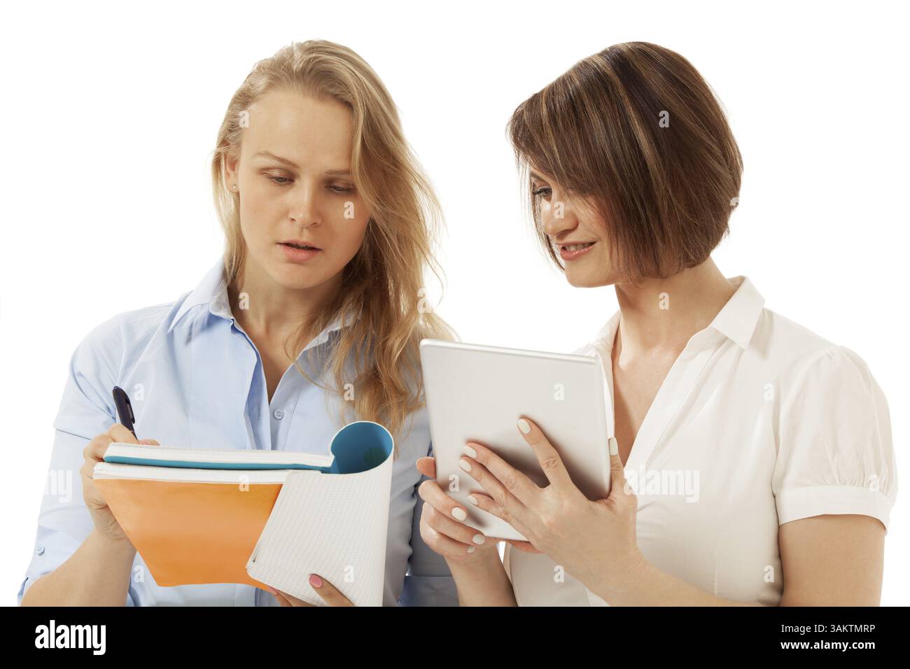 Two colleagues looking at notebook. White background. Isolated, studio shot Stock Photo