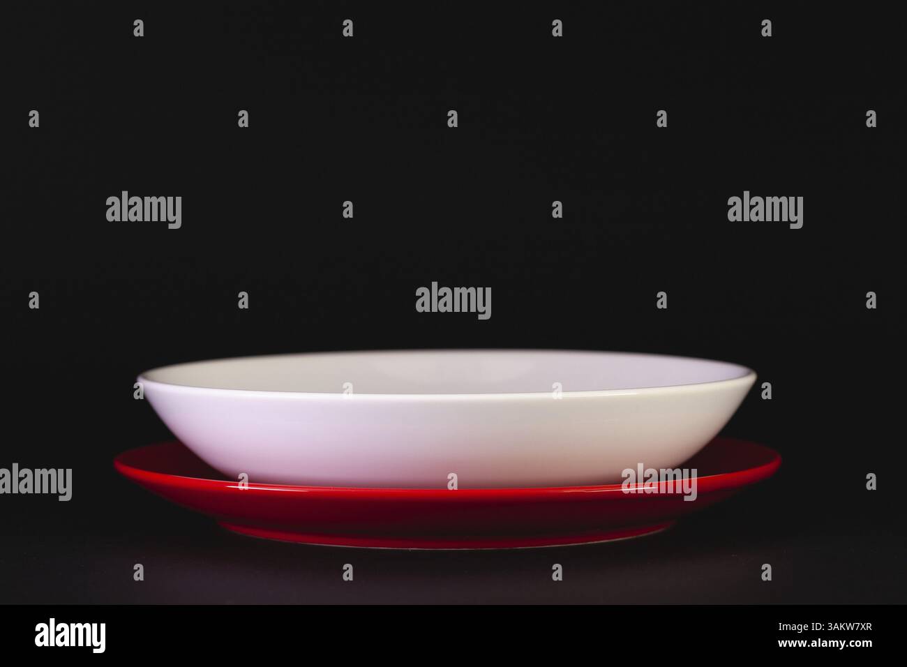 Empty red and white plates on the black background Stock Photo