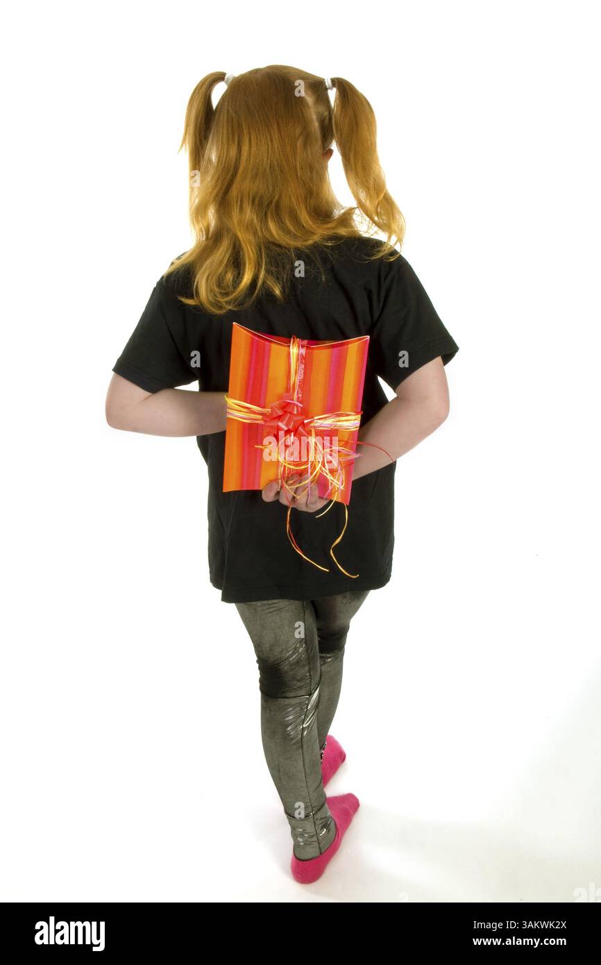Red haired girl is hiding a present Stock Photo