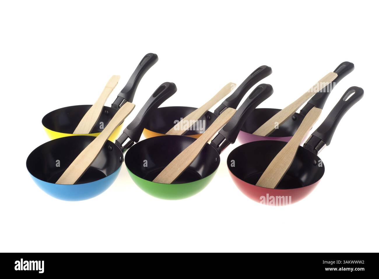 Many stacked colorful frying pans isolated over white Stock Photo