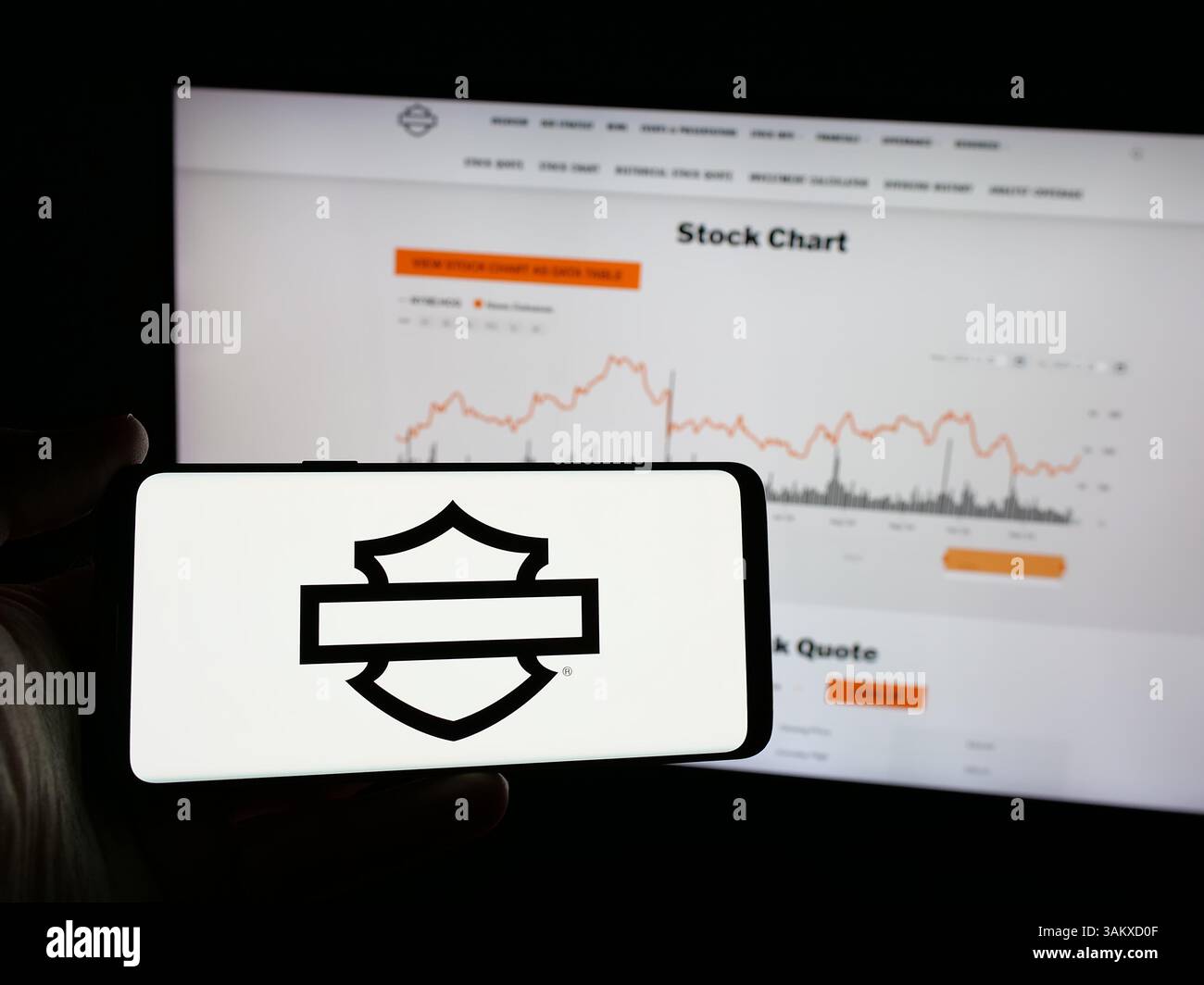 Stuttgart, Germany - 11-26-2024: Person holding smartphone with logo of US motorcycle company Harley-Davidson Inc. on screen in front of website. Stock Photo