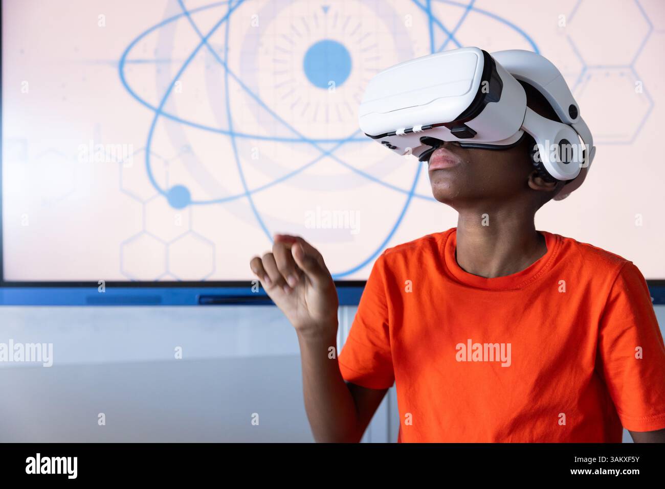 Using VR headset, student exploring virtual reality in school classroom Stock Photo