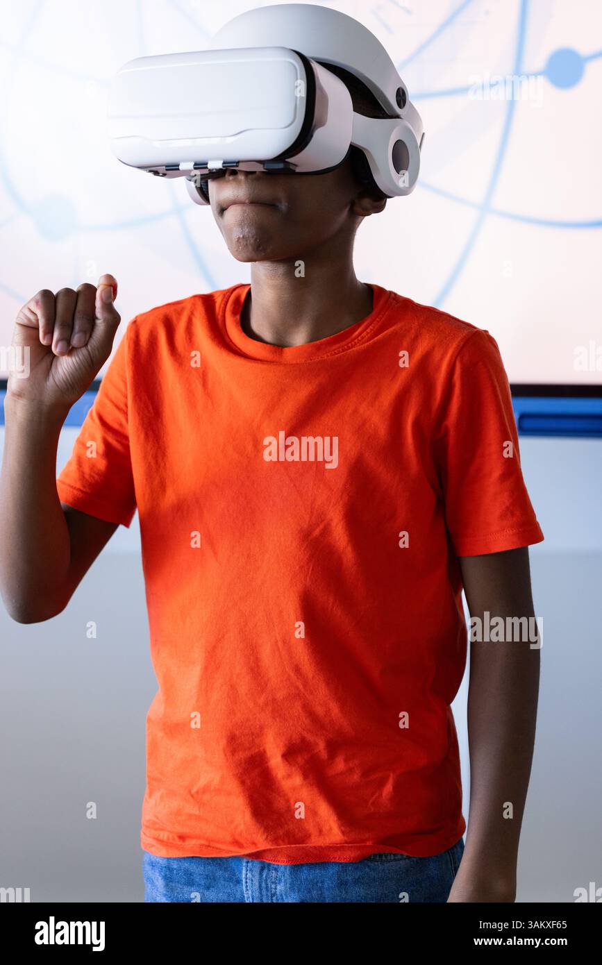 Using VR headset, boy in school exploring virtual reality experience Stock Photo