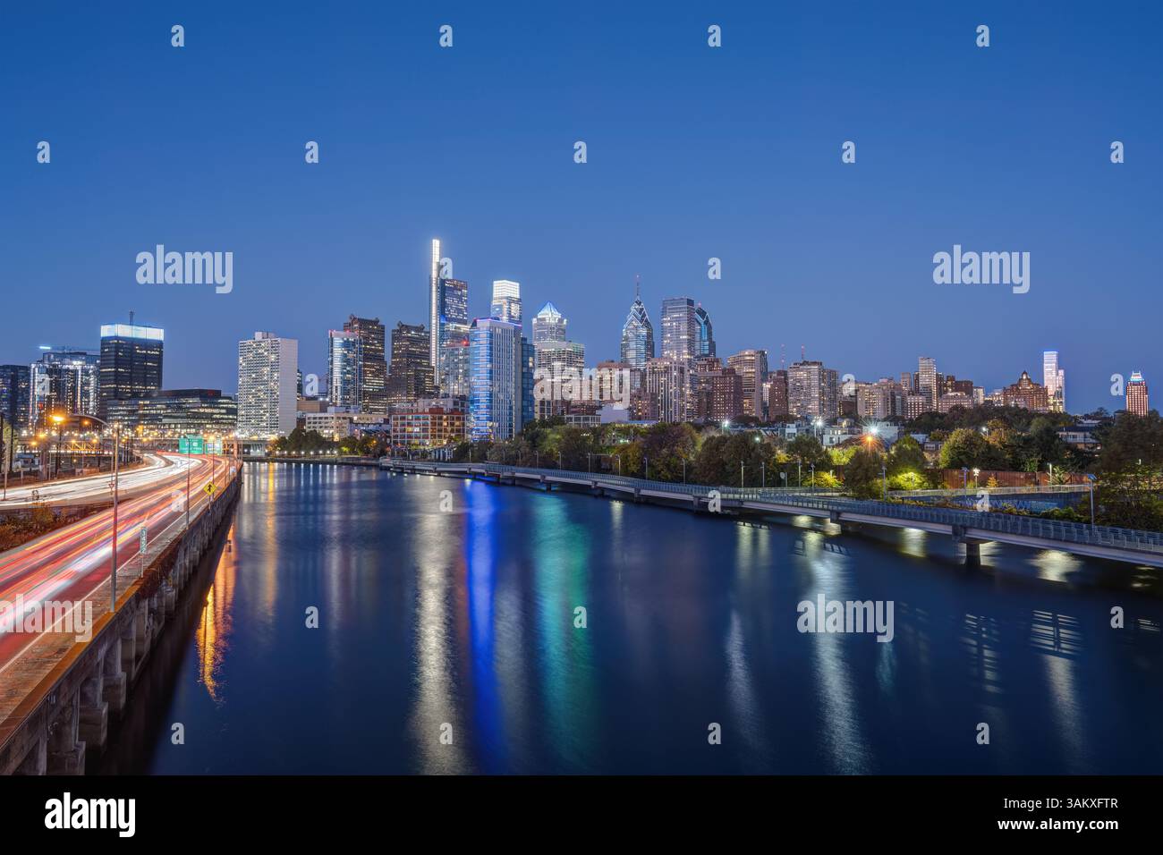 The skyline of downtown Philadelphia with the Schuylkill River and a highway at night Stock Photo