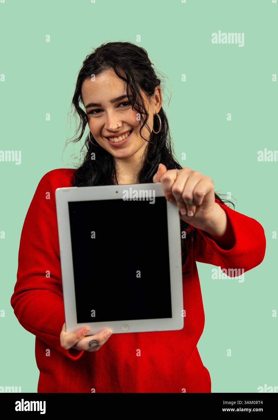 Smiling young woman showing digital tablet with blank screen, promoting app or website Stock Photo