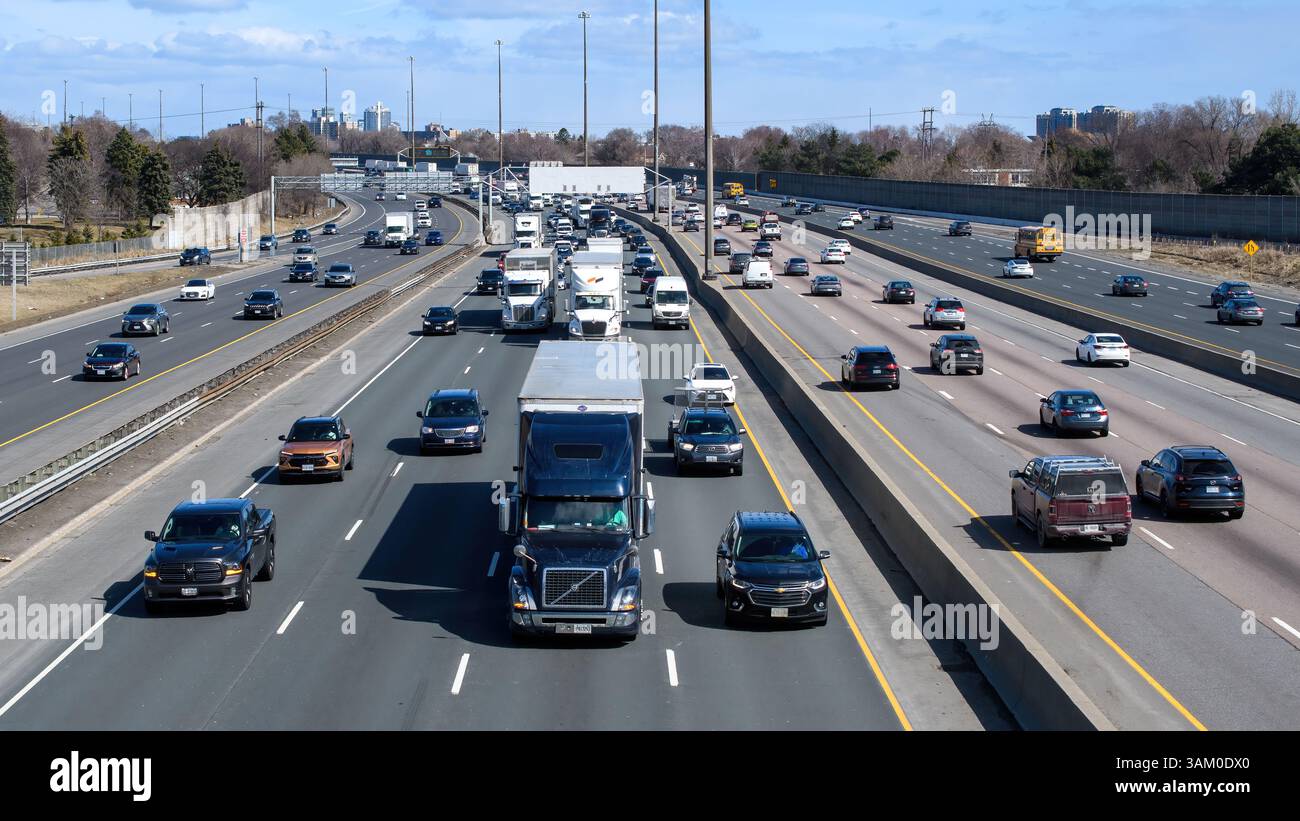 Trailer trucks and other vehicles driving on Highway 401. Stock Photo