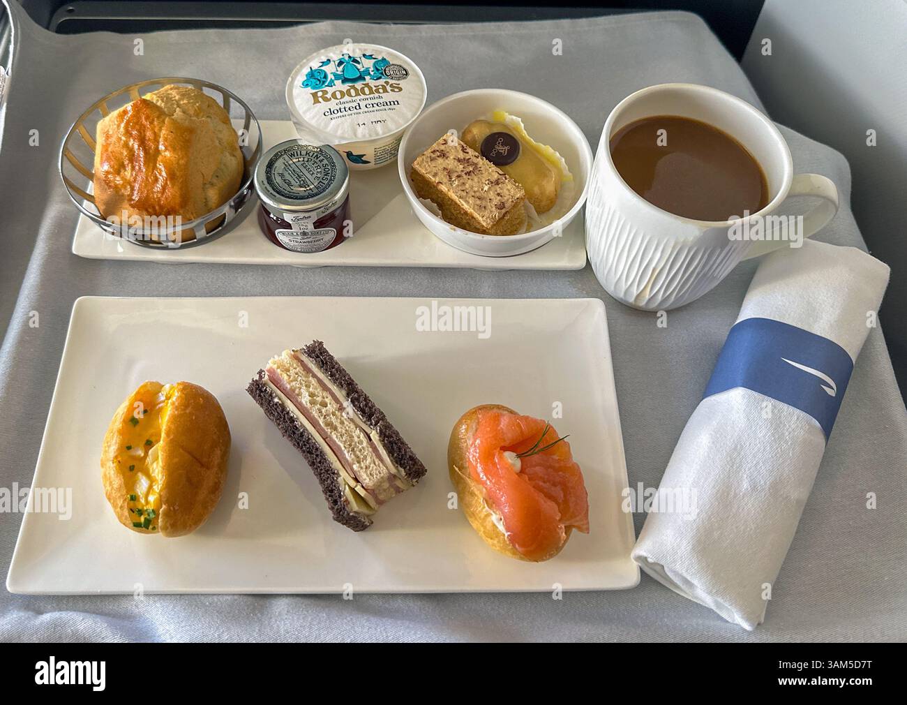 En route Uk to USA - 29 April 2024: tray of afternoon tea in the Club World business class cabin on a British Airways flight. - Smartphone Captured Stock Image