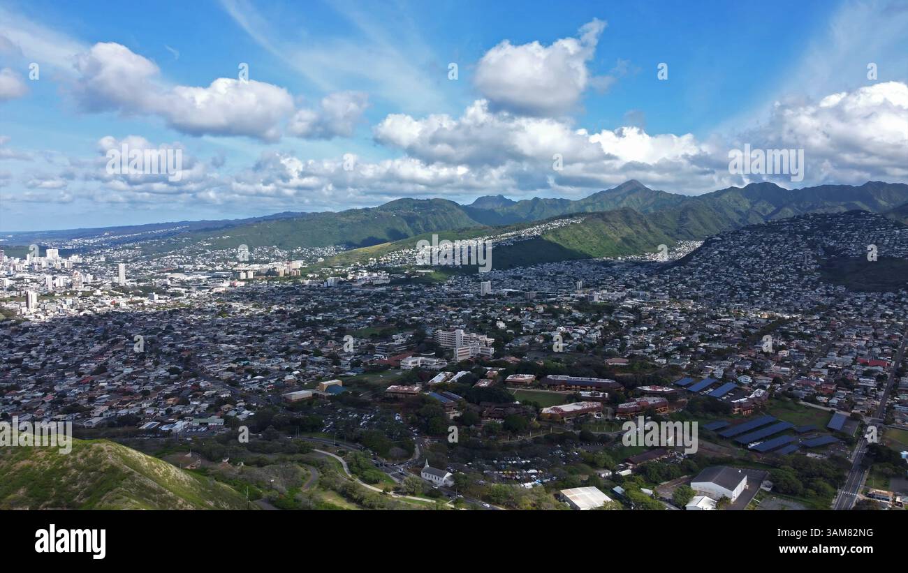 Aerial view of Honolulu with lush green mountains, urban skyline, and ...