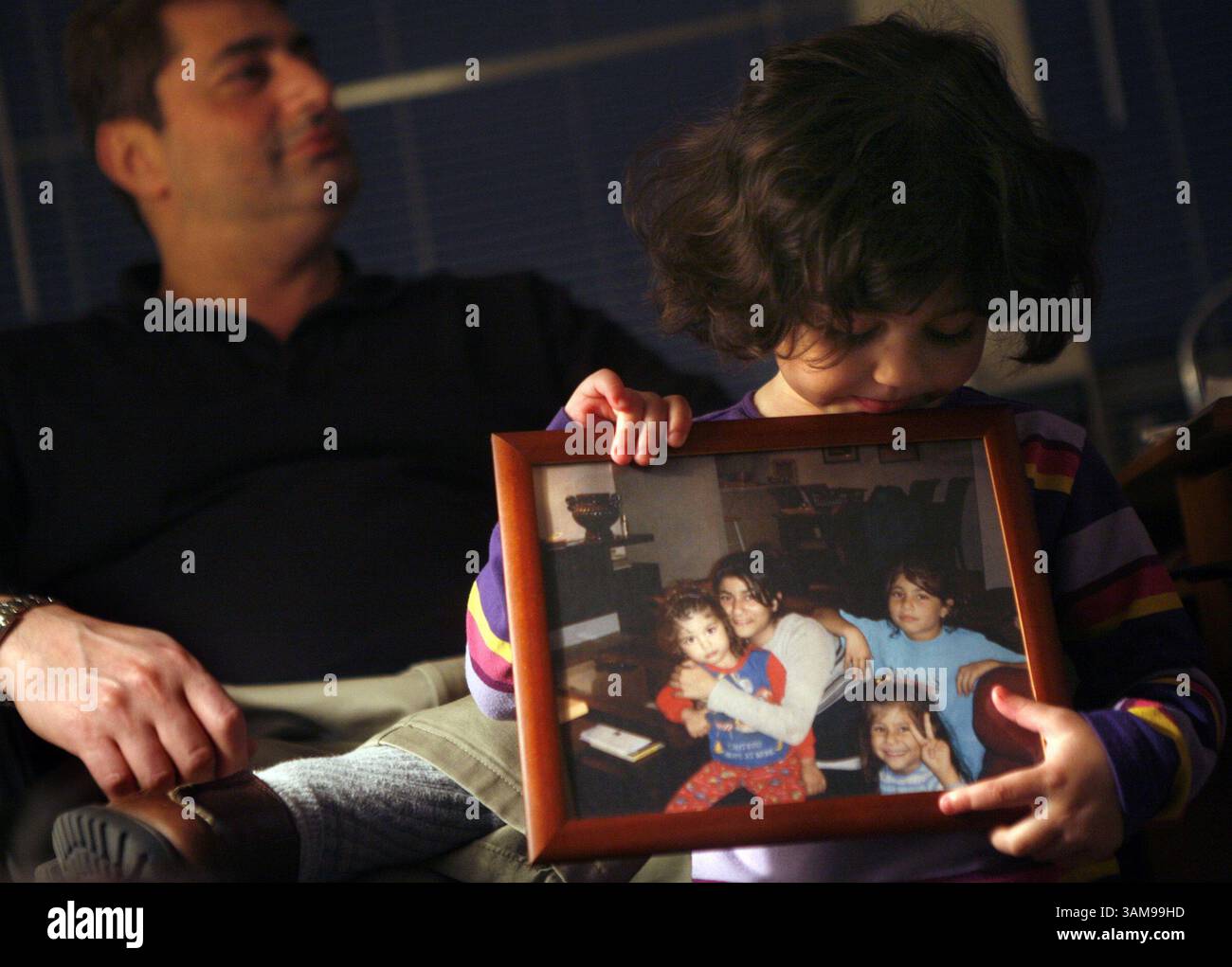 Feb. 2, 2007 - U.S. - Zahra Ibrahim, a 3-year-old U.S. Citizen, holds a picture of her sisters (starting second from left) Rodaina, 14, Faten, 5, and Maryam, 8, at her uncle's, Ahmad Ibrahim (left), apartment in Dallas, Texas, January 31, 2007. The Palestinian girls and her parents are awaiting deportation in a federal jail. Zahra is the only one of the family who is not jailed because she was born in the United States. (Tom Fox/Dallas Morning News/MCT) (Credit Image: © Tom Fox/mct/ZUMAPRESS.com) Stock Photo