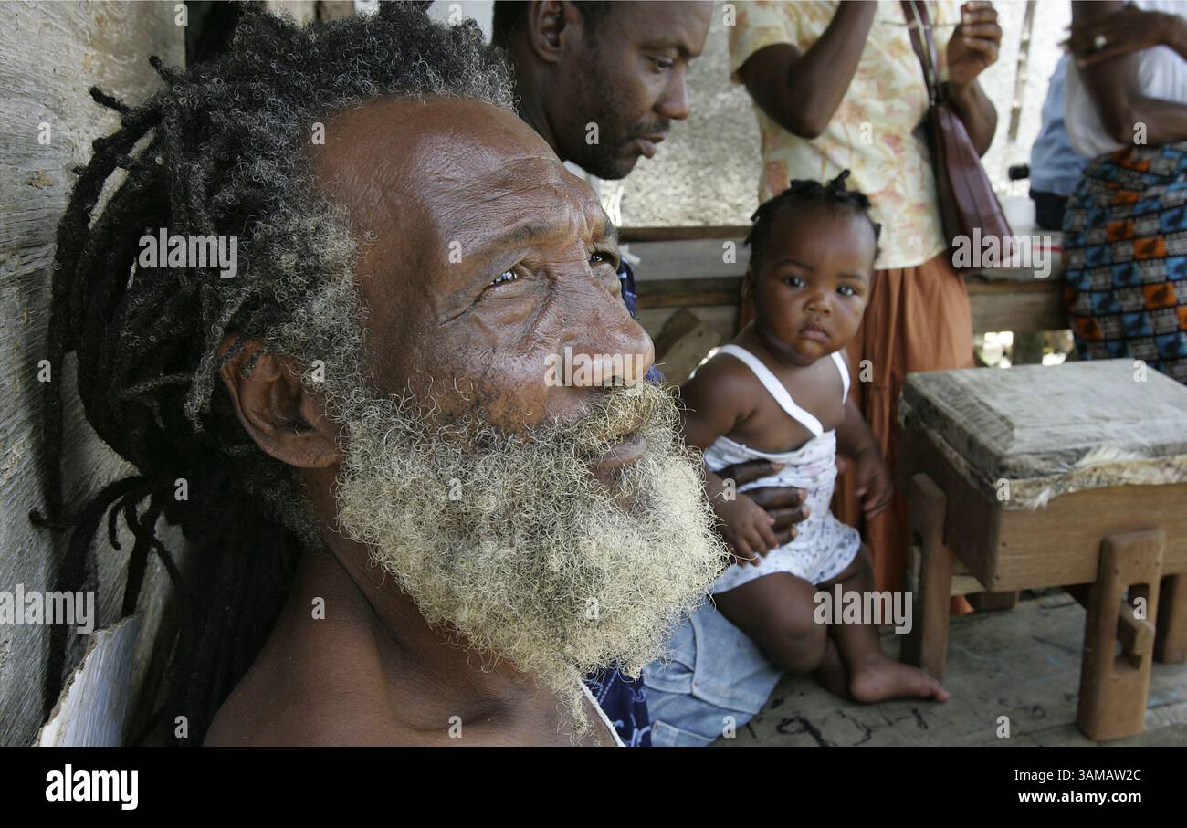Aug. 22, 2007 - Gorge Huggins, left, talks about the cultural connection between his ancestors and the drum, as Neville McLeggon, 46, plays with daughter Nevisha, 7-months, August 22, 2007, in Accompong Town, Jamaica. As the English-speaking Caribbean marks the bicentenary of Britain's abolition of the slave trade, Jamaicans are told to celebrate their ancestors who led the anti-slavery effort. (Carl Juste/Miami Herald/MCT) (Credit Image: © Carl Juste/MCT/ZUMAPRESS.com) Stock Photo