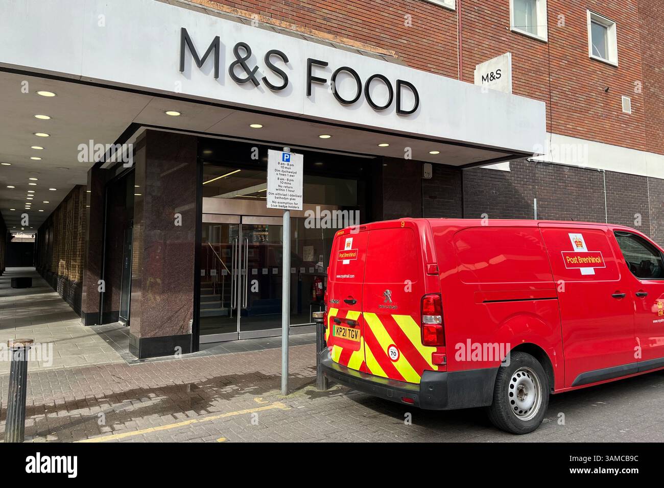 M&S Food Storefront with a Royal Mail Van parked outside. Cardiff, Wales, United Kingdom. 12th April 2025. - Smartphone Captured Stock Image