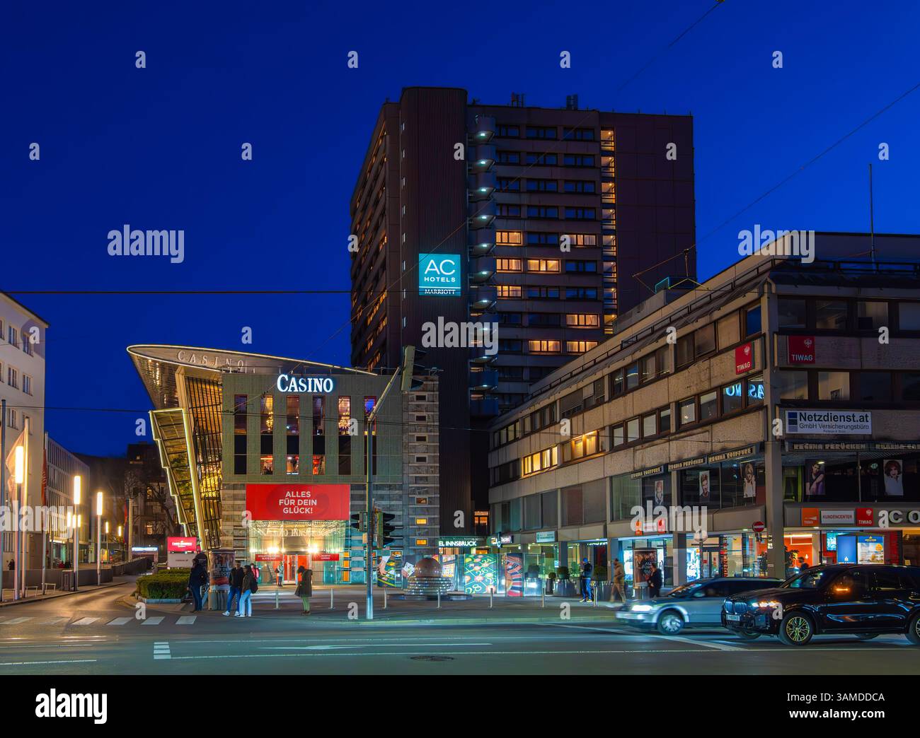 Innsbruck, Austria - March 20, 2025: Urban scene at dusk in Innsbruck featuring a modern casino building, AC Marriot Hotel and other commercial buildi Stock Photo