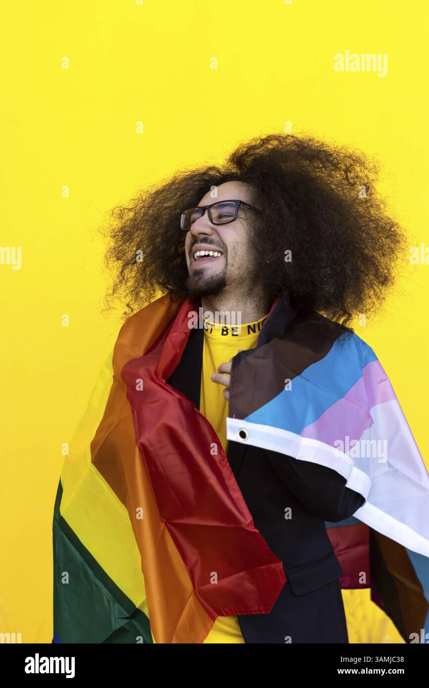 Happy smiling gay man wrapping with a rainbow lgbt flag Stock Photo - Alamy