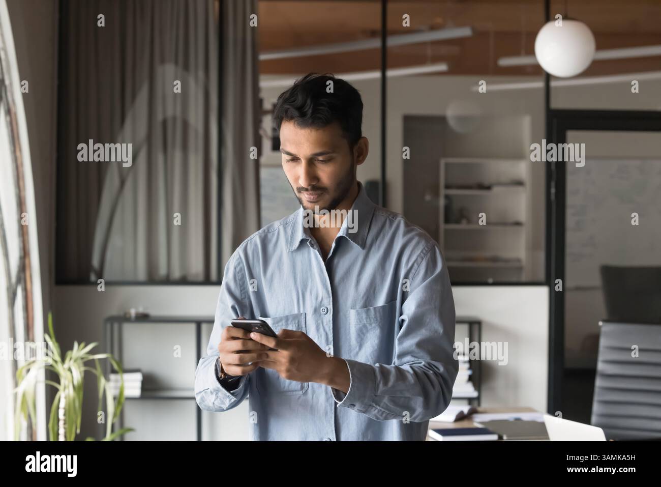 Successful Modern Indian Businessman using smartphone Stock Photo