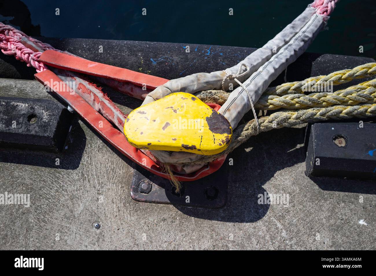 A yellow object is tied to a rope. The rope is red and white Stock ...