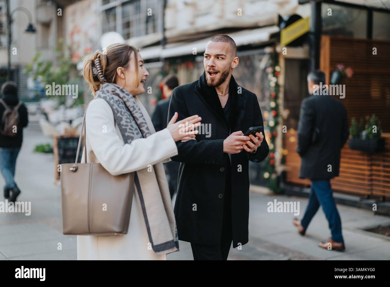 Friends engaging in a lively conversation while walking together outdoors Stock Photo