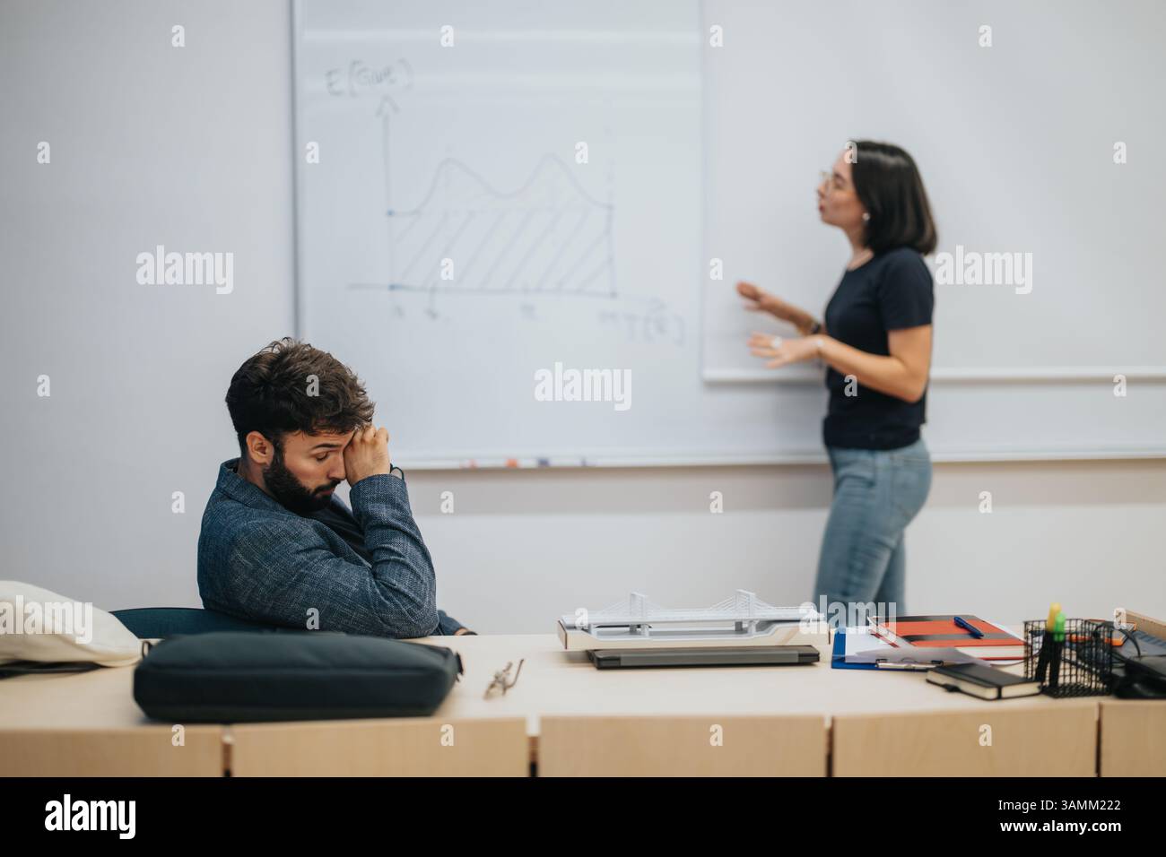 Teacher explaining mathematical concept to attentive student in classroom Stock Photo